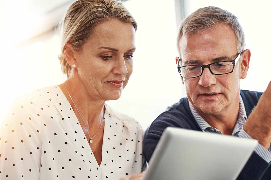 Älteres Paar betrachtet gemeinsam einen Laptopbildschirm