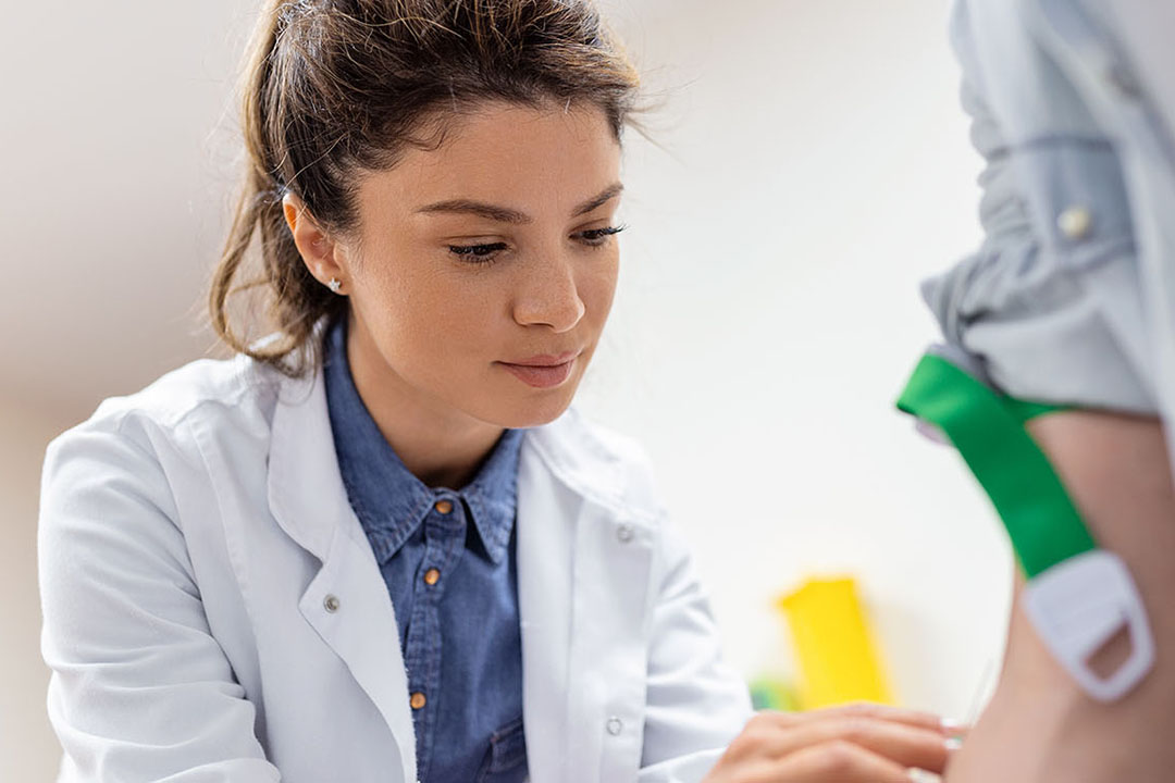 Eine Ärztin nimmt einer Patientin Blut ab