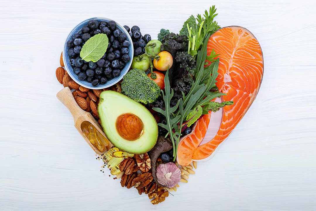 Avocado, Lachs, verschiedene Gemüse, Nuesse und Kräuter zu einem Herz zusammengelegt