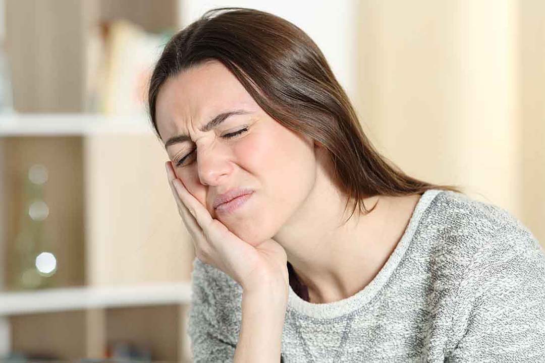 Eine Frau mit schmerzender Backe