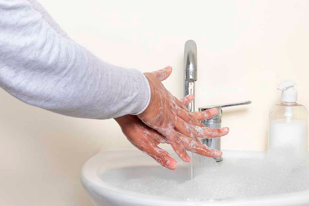 Hände waschen mit Seife im Waschbecken