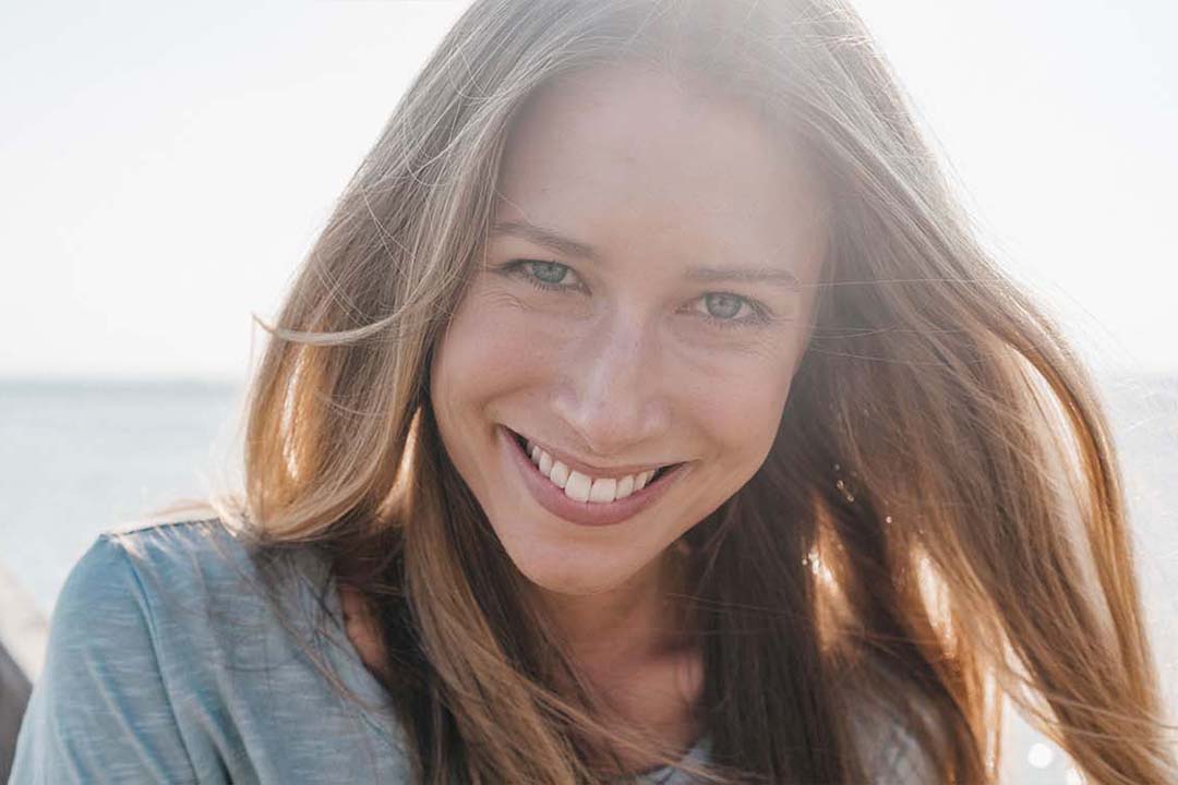 Lächende Frau auf einem Steg am Meer