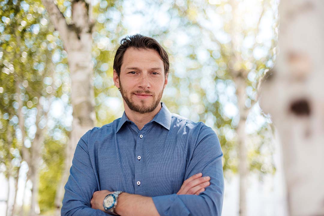 Mann mit verschränkten Armen in blauem Hemd