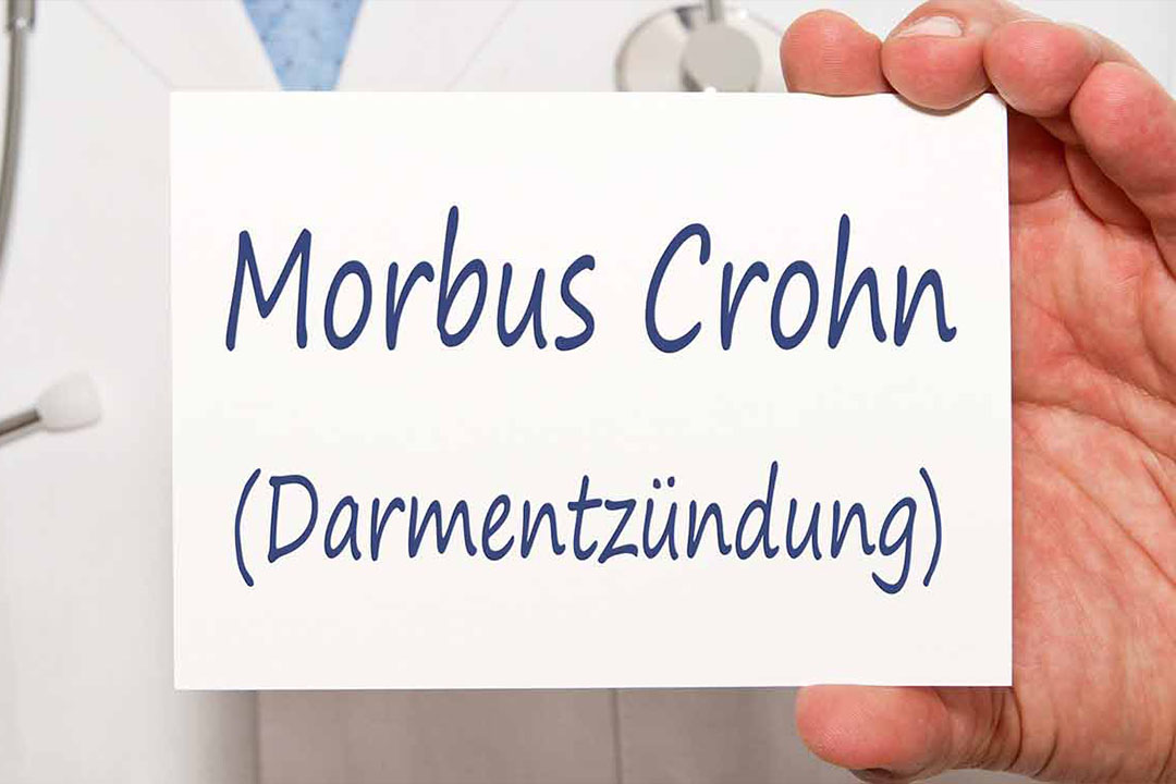 Nahaufnahme Arzt hält Zettel mit Aufschrift Morbus Crohn