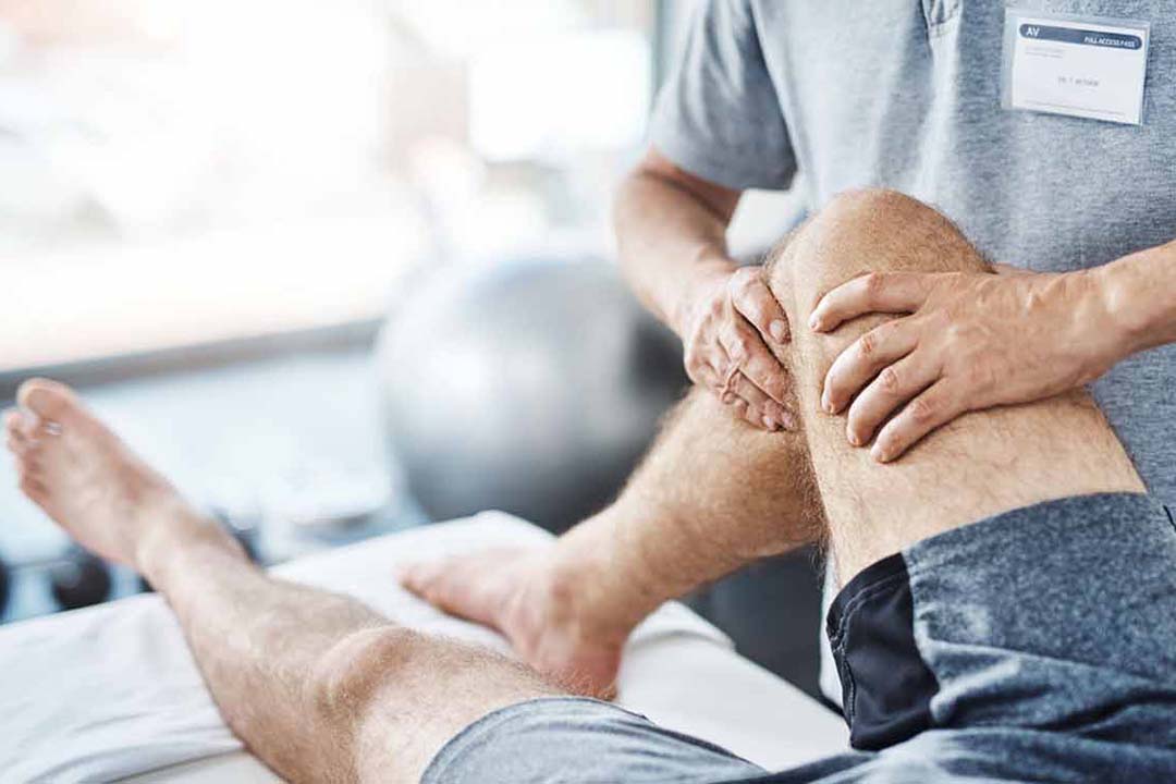 Physiotherapeut behandelt ein Knie