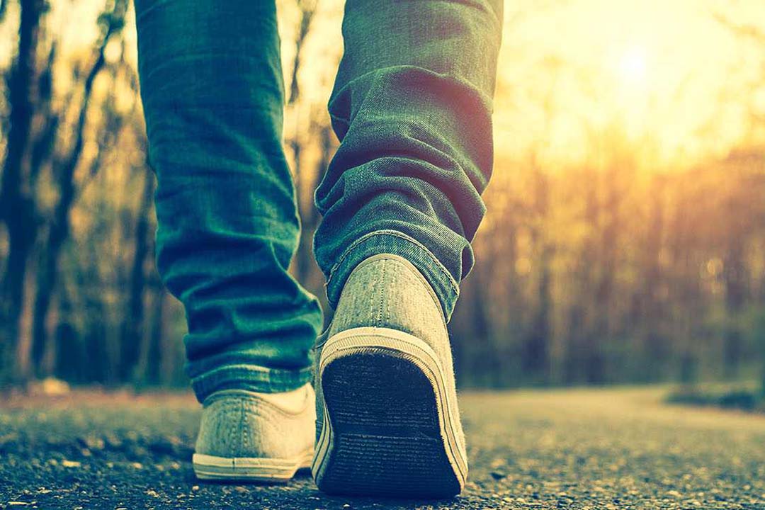 Nahaufname von einer Person die Spazieren geht - die Füße sind von hinten zu sehen