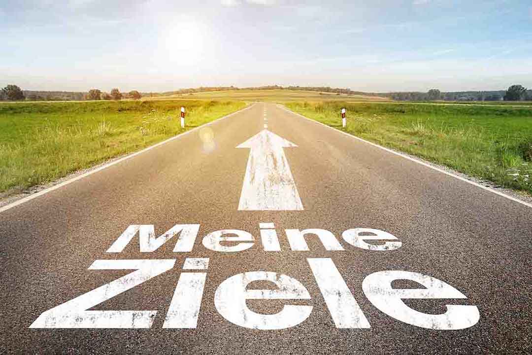 Schriftzug-auf-Landstrasse mit einem Pfeil auf dem Asphalt der nach vorne zeigt und ein Schriftzug Meine Ziele