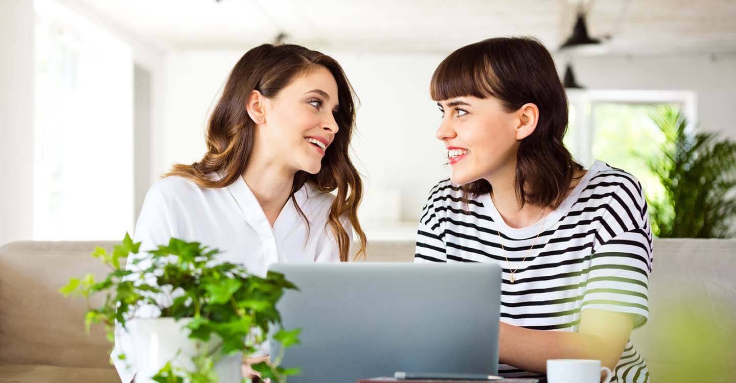 Zwei Frauen sitzen gemeinsam am Laptop