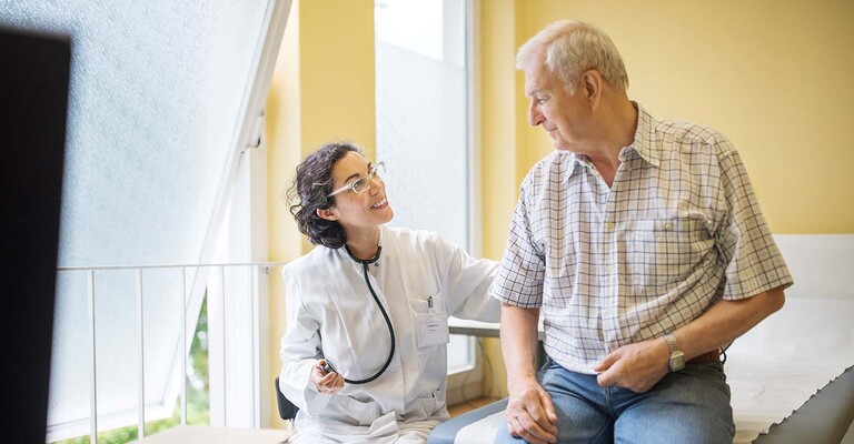 Ärztin spricht mit einem Patienten