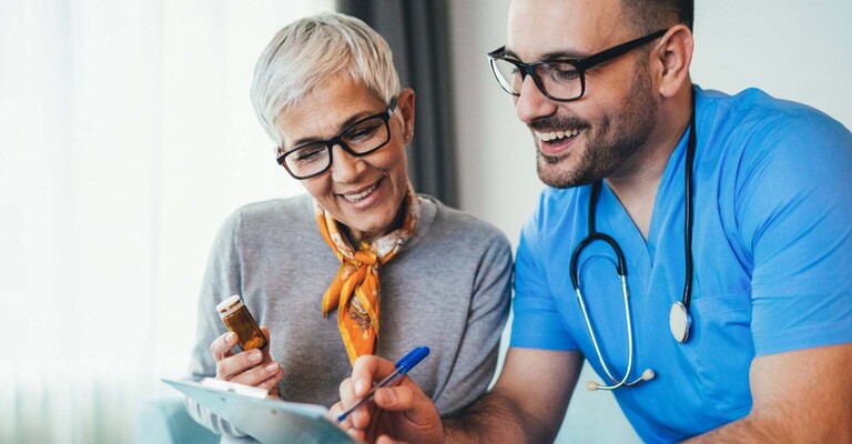 Arzt mit Klemmbrett und Frau mit Medikamentendose