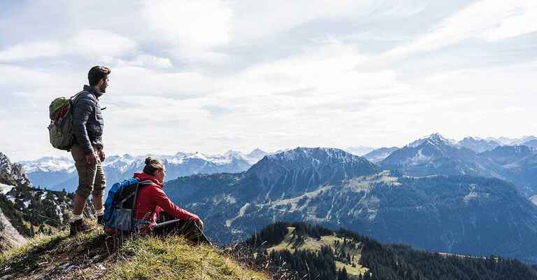 Ein Paar geniesst die Weite einer Berglandschaft