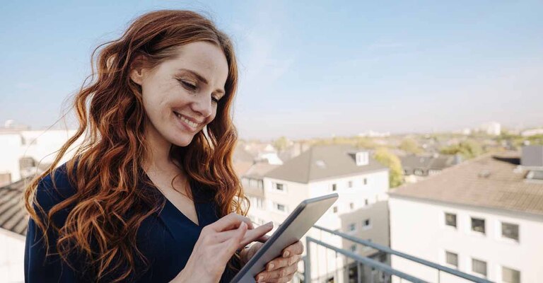 Frau auf Dachterasse mit Notepad