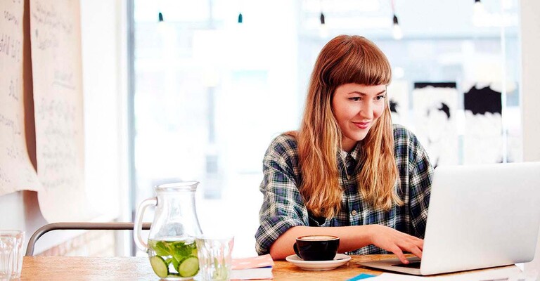 Frau im Kaffee arbeitet an einem Laptop