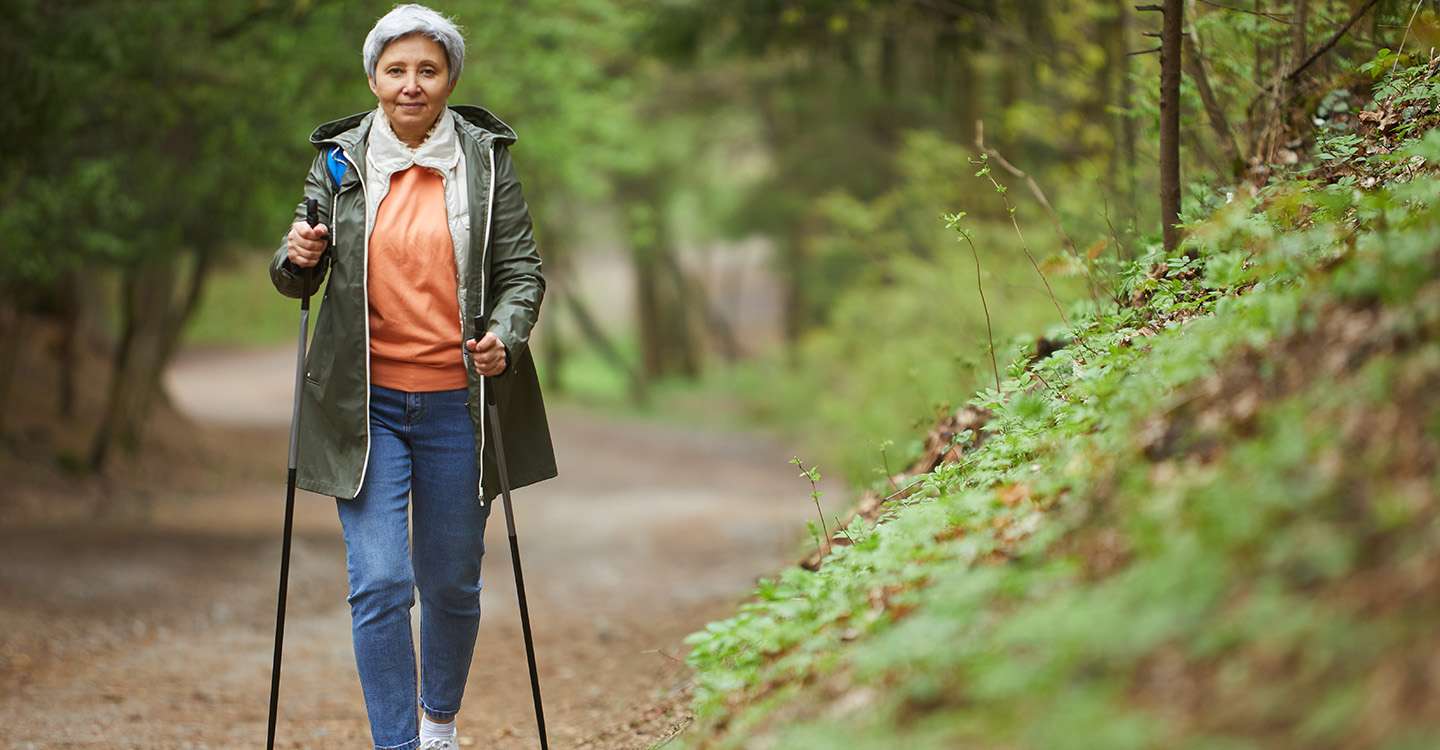 Frau betreibt Nordic Walking im Wald