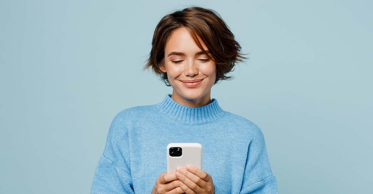 Frau im blauen Pullover vor blauem Hintergrund