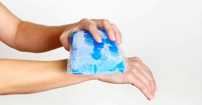 Hand wird mit einem Eispack gekühlt