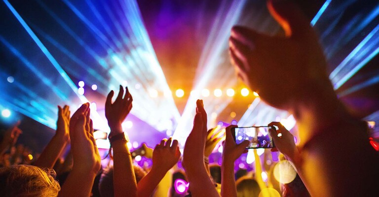 Junge Menschen tanzen bei einer Lasershow