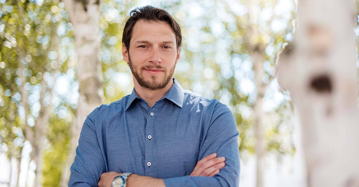 Mann mit verschränkten Armen in blauem Hemd