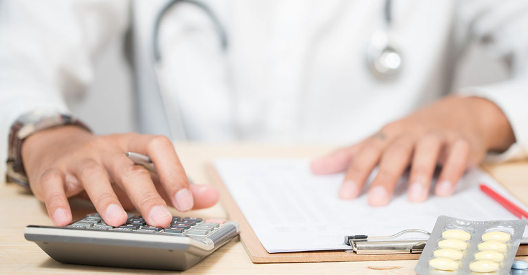 Nahaufnahme Arzt mit Klemmbrett und Taschenrechner