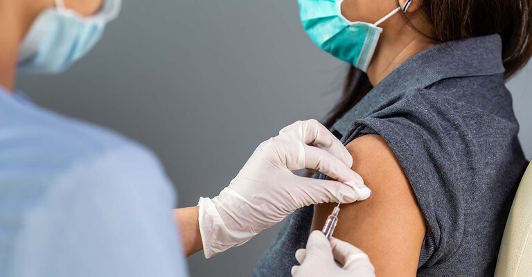 Patientin erhält eine Spritze in den Oberarm