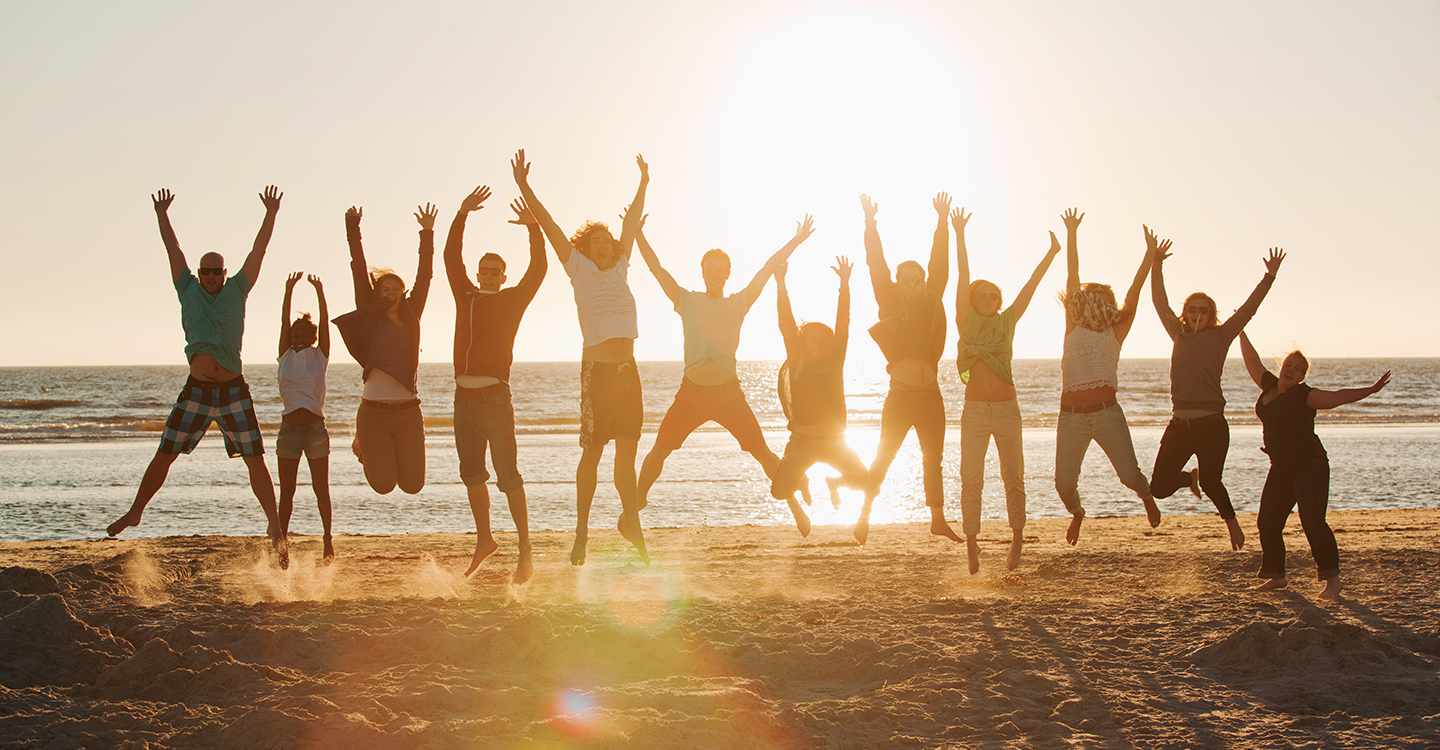 Eine Gruppe Menschen am Strand, die hochspringen