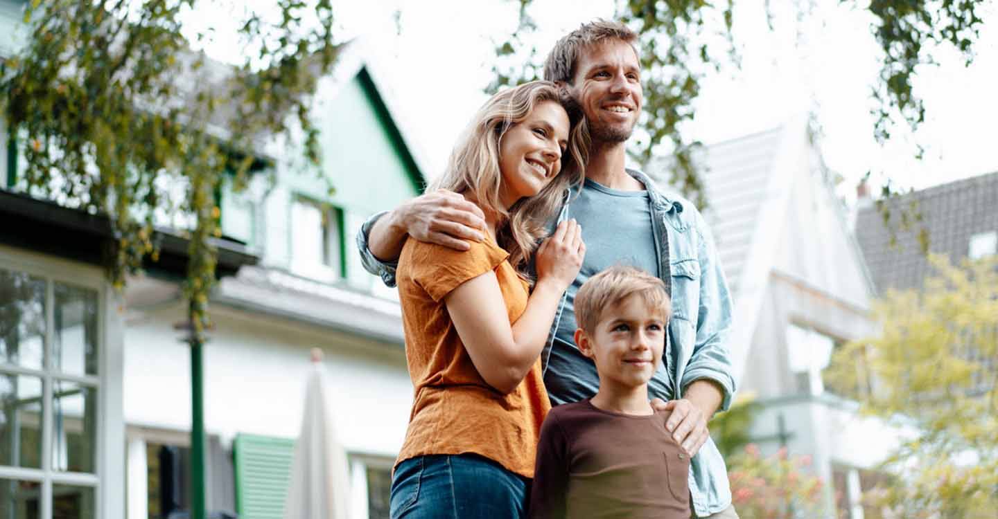 Vater, Mutter und Kind vor dem Haus