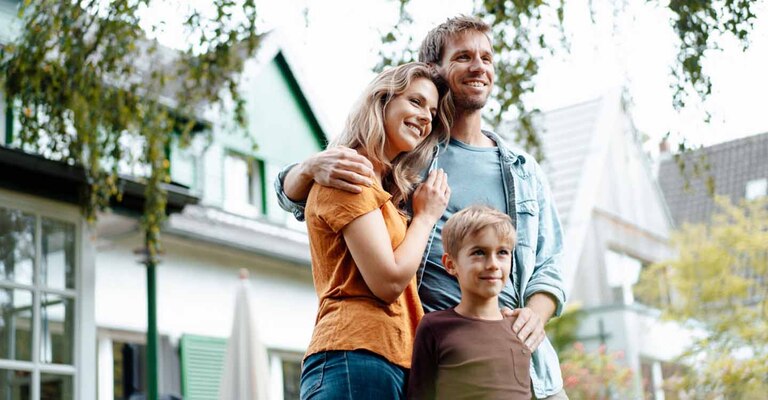 Vater, Mutter und Kind vor dem Haus