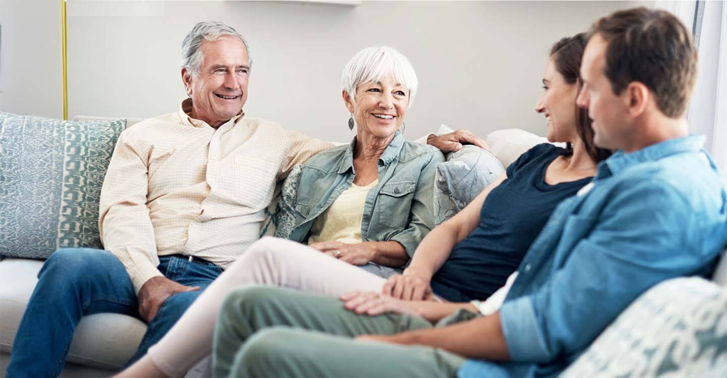 Vier Menschen sitzen auf einem Sofa