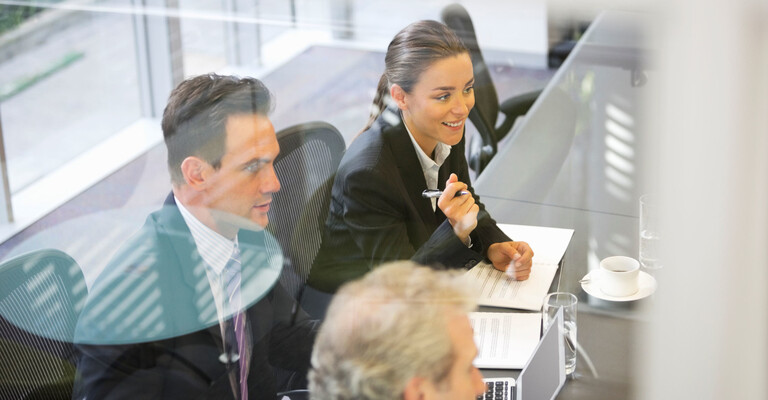 Teambesprechung - Kollegen sitzen in einem Meetingsraum und besprechen ein Thema