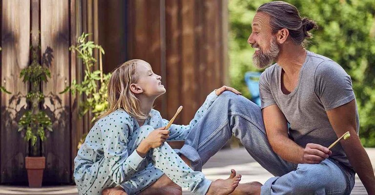 Vater und Tochter zeigen sich gegenseitig die Zähne