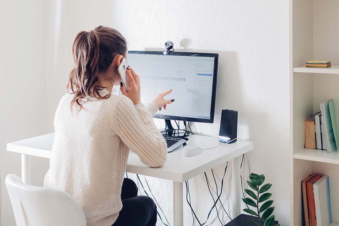 Frau im Homeoffice, die am Computer telefoniert
